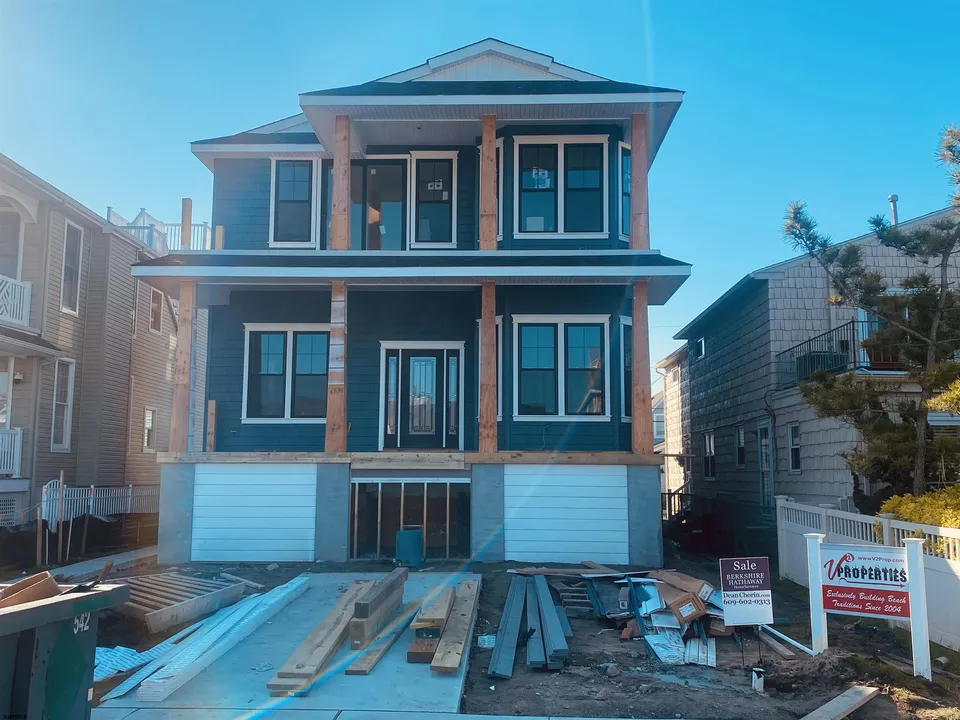 We see a 2-story, blue house in Ocean City, NJ against a clear blue sky.