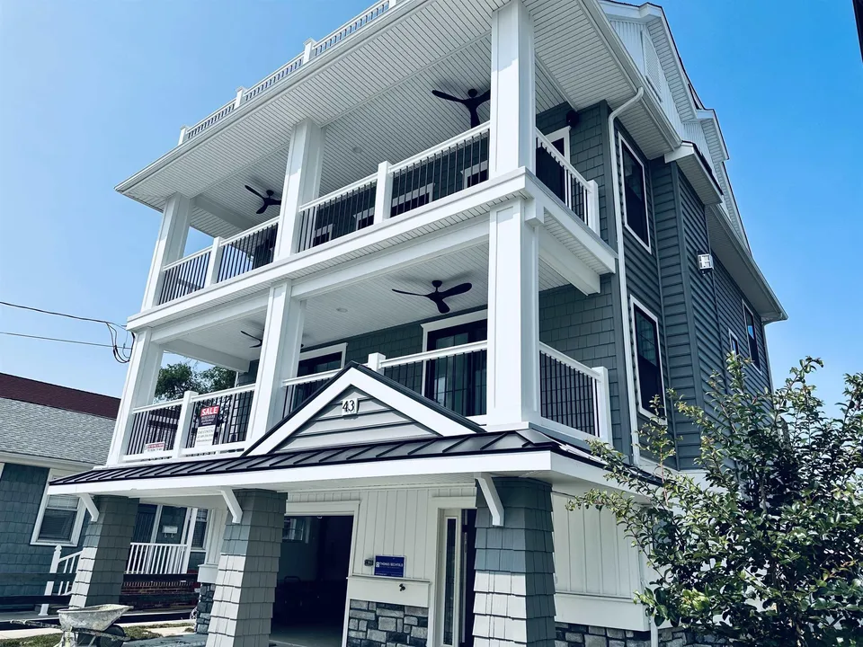We see a white and blue house in Ocean City, NJ against a clear blue sky.