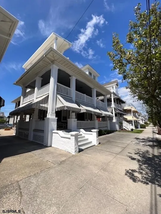 We see the corner of a white house against a clear blue sky in Ocean City, NJ.