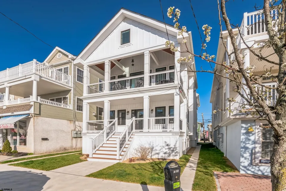 We see the front of a white house in Ocean City, NJ against a clear blue sky.