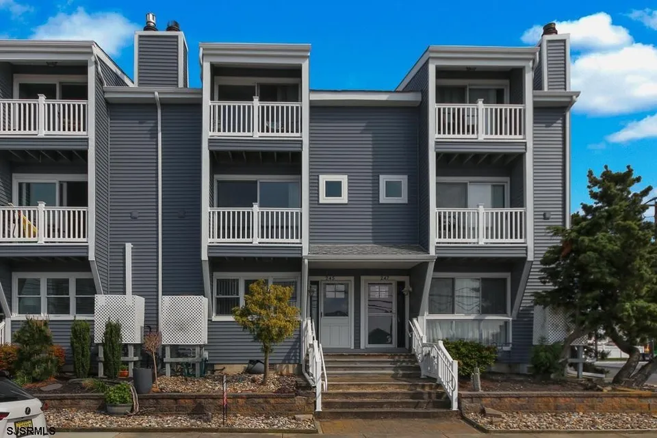 A grey condominium in Ocean City, NJ against a clear blue sky.
