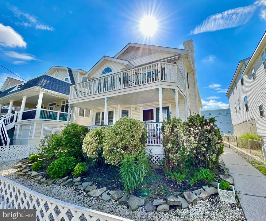 A beige and white house in Ocean City, NJ against a sunny sky.