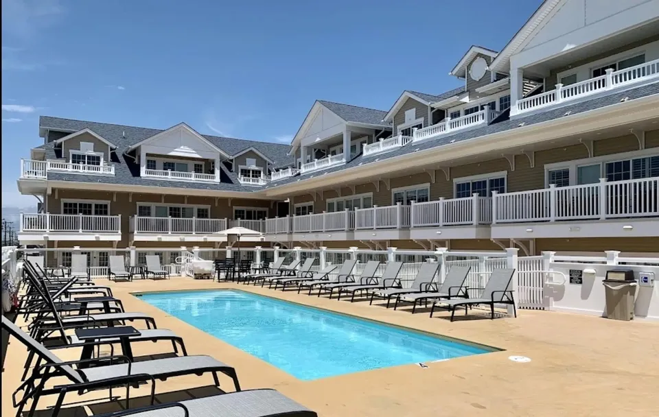 We the front of a condo in Ocean City, NJ against a clear blue sky. The condo pool is also in view.
