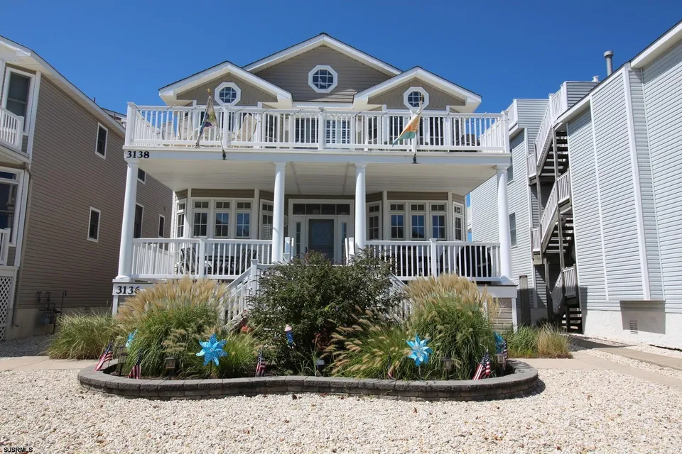 A beige and white house in Ocean City, NJ against a clear blue sky.